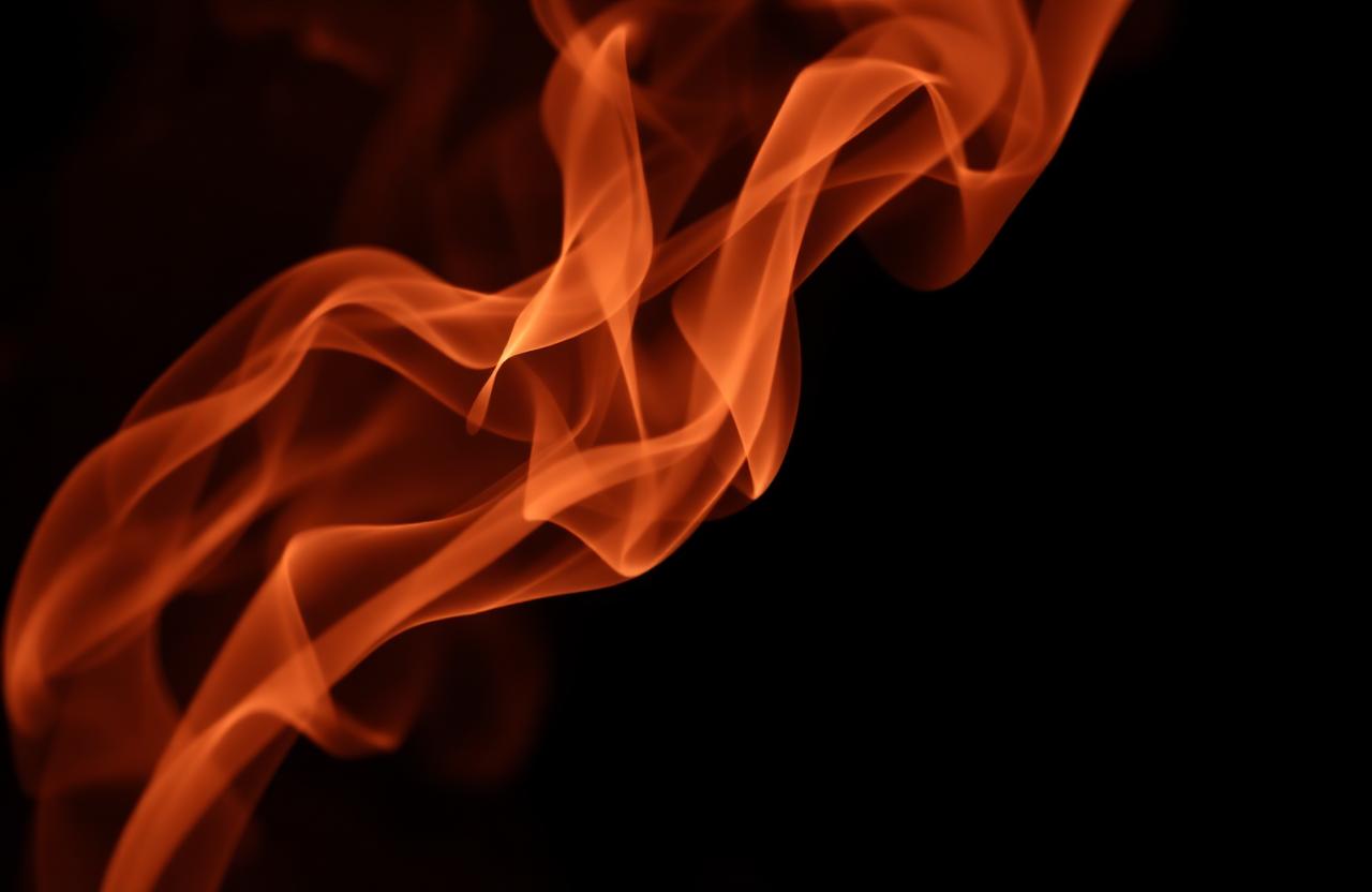 Saffron incense smoke against dark space